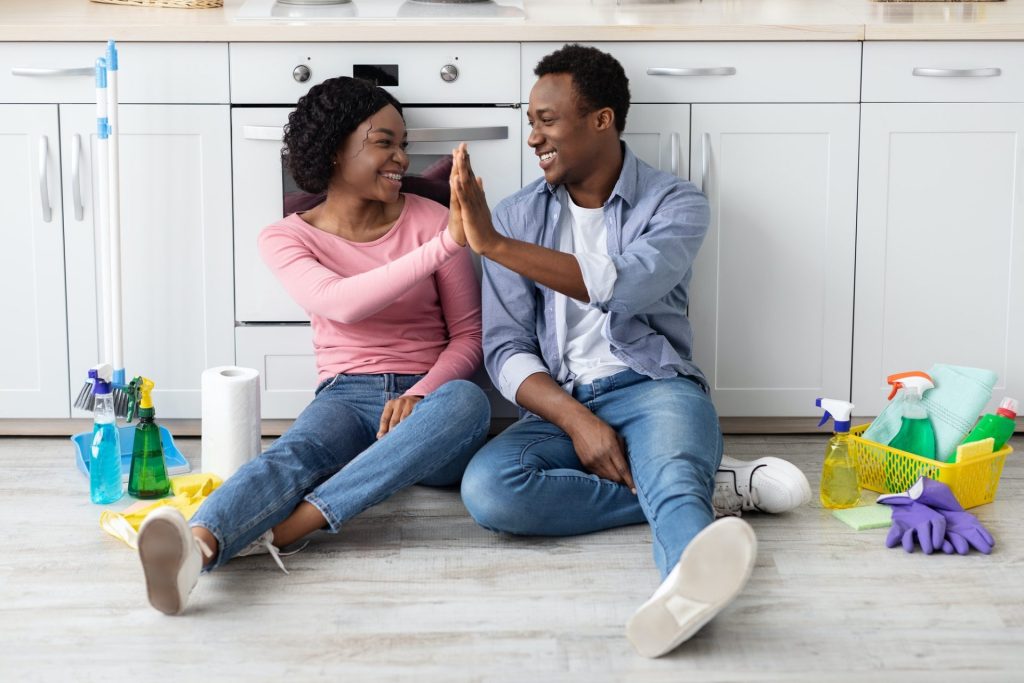 Lovers giving high five to each other, resting after cleaning